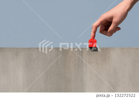 Hand adjusting red emergency beacon on modern concrete roof minimal style clear blue sky background safety concept calm atmosphere outdoor urban setting alert device contemporary architecture Hand adjusting red emergency beacon on modern concrete roof minimal style clear blue sky background safety concept calm atmosphere outdoor urban setting alert device contemporary architecture 132272522
