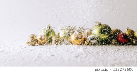 Christmas ornament artificial snow festive holiday decoration winter celebration glitter colorful cheerful sparkle seasonal joyful background white gold green red silver shiny ball hand sprinkle 132272600