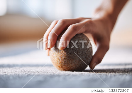 Close up of hand gently pressing textured massage ball on soft mat, creating calm and relaxing atmosphere for self care and physical therapy routines Close up of hand gently pressing textured massage ball on soft mat, creating calm and relaxing atmosphere for self care and physical therapy routines 132272807