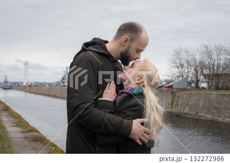 Romantic man and woman couple hugging each other kissing at seaside 132272986