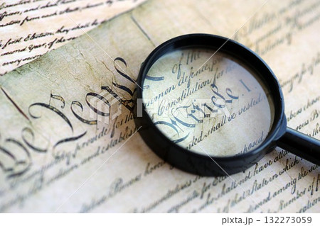 Magnifying glass and United States Constitution. American USA Constitution paper page and loupe close up 132273059