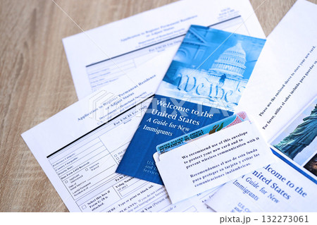 Permanent resident green card in envelope with application and guide for new immigrants lies on table close up 132273061