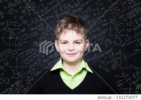 Smiling school child boy in classroom on chalkboard background. Education and back to school concept Smiling school child boy in classroom on chalkboard background. Education and back to school concept 132273077