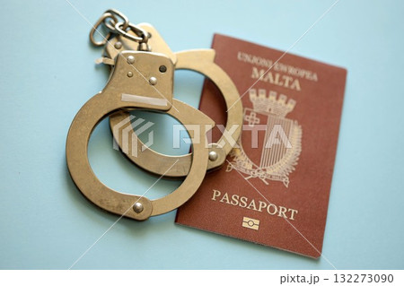 Malta passport with police handcuffs on table close up. Criminal level and arrests in Europe concept Malta passport with police handcuffs on table close up. Criminal level and arrests in Europe concept 132273090