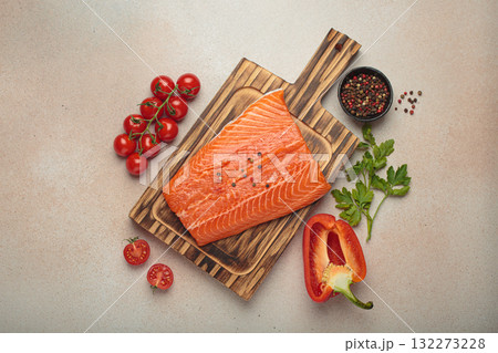Fresh raw salmon fillet with cooking ingredients on wooden board top view on light beige background Fresh raw salmon fillet with cooking ingredients on wooden board top view on light beige background 132273228