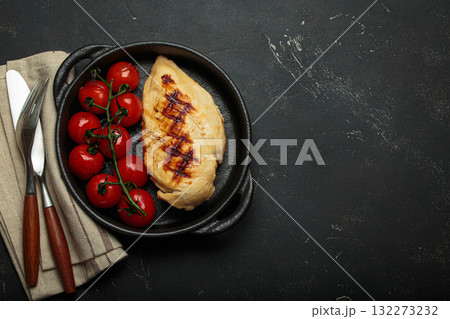 Grilled chicken breast fillet with cherry tomatoes in cast iron pan top view on rustic black background, healthy food, space for text Grilled chicken breast fillet with cherry tomatoes in cast iron pan top view on rustic black background, healthy food, space for text 132273232