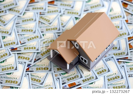 Toy house on big amount of US dollar bills close up. Real estate and building construction concept 132273267