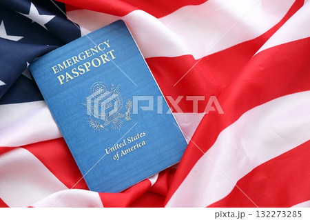 United States emergency passport book on US flag close up. Travel document on official banner photo United States emergency passport book on US flag close up. Travel document on official banner photo 132273285