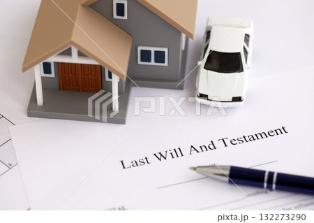 Generic toy house with car and Last will and testament with pen on table close up 132273290
