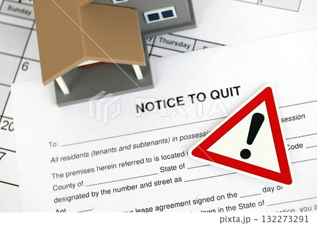 Generic toy house and eviction notice or notice to quit on table close up 132273291