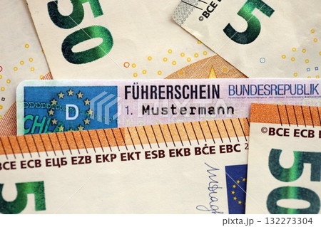German driving license card called Fuhrerschein lies on big amount of Euro money close up 132273304