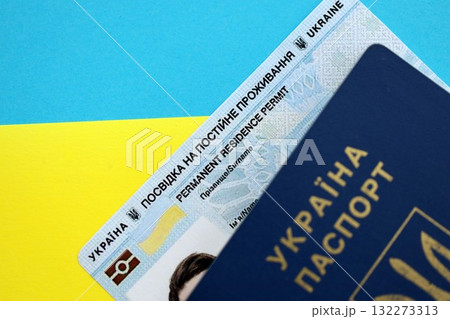 Ukrainian residence permit card or permanent resident card with passport on Ukraine flag close up Ukrainian residence permit card or permanent resident card with passport on Ukraine flag close up 132273313