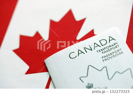 Canadian temporary passport lies on canadian flag close up Canadian temporary passport lies on canadian flag close up 132273325