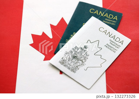 Canadian temporary and permanent passports lies on flag close up Canadian temporary and permanent passports lies on flag close up 132273326