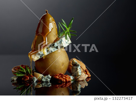 Blue cheese with honey, pear, walnuts, and rosemary on a black background. 132273417