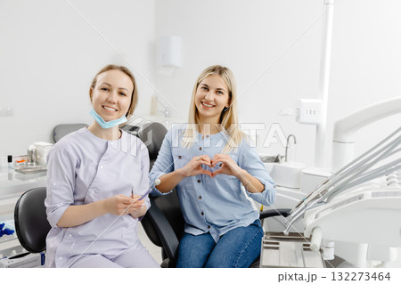 Dentist and patient making heart shape with hands in dental clinic 132273464