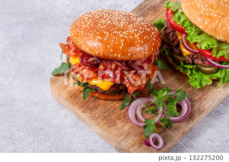 two burgers with beef patty, fried bacon, cheddar cheese, tomatoes, homemade, no people, 132275200