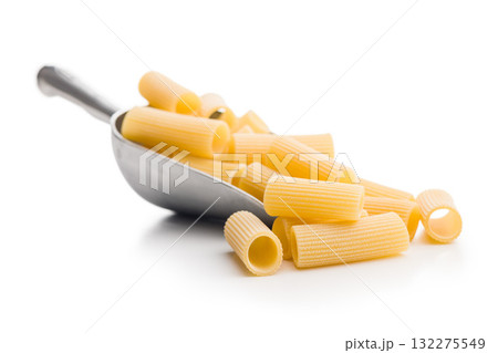 Uncooked rigatoni pasta in scoop isolated on white background. 132275549
