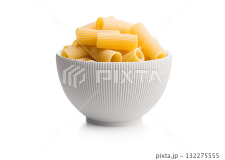 Uncooked rigatoni pasta in bowl isolated on white background. 132275555