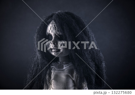 Portrait of a scary cracked doll with black hair on dark background Portrait of a scary cracked doll with black hair on dark background 132275680