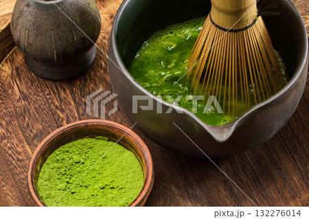 Matcha Preparation Scene. A traditional matcha tea whisking scene featuring vibrant green tea 132276014