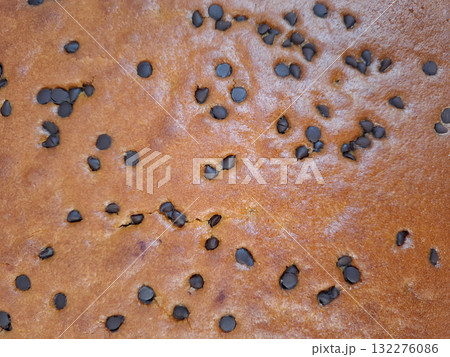 A freshly baked chocolate chip pie showcases a golden brown crust dotted with melted chocolate chips, filling the kitchen with a delightful aroma. Perfect for dessert. A freshly baked chocolate chip pie showcases a golden brown crust dotted with melted chocolate chips, filling the kitchen with a delightful aroma. Perfect for dessert. 132276086