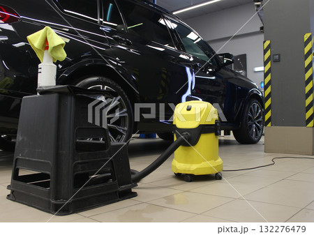 Puddles on the floor of a service station after wet cleaning the car interior with a wet vacuum cleaner Puddles on the floor of a service station after wet cleaning the car interior with a wet vacuum cleaner 132276479