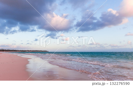 Soft sand meets turquoise water under a blue sky with scattered clouds 132276590