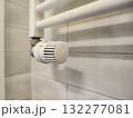 White wall-mounted radiator with an adjustable thermostat valve, featuring a plastic knob with numbered settings for temperature control 132277081