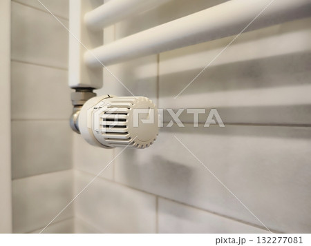 White wall-mounted radiator with an adjustable thermostat valve, featuring a plastic knob with numbered settings for temperature control White wall-mounted radiator with an adjustable thermostat valve, featuring a plastic knob with numbered settings for temperature control 132277081