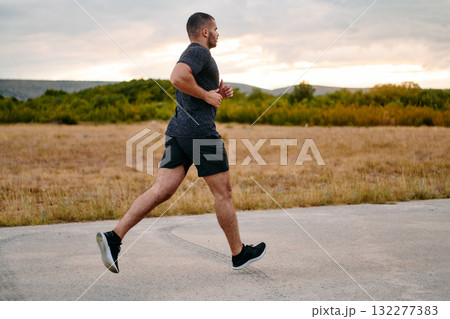 Athletic Man Jogging in the Sun, Preparing His Body for Life's Extreme Challenges Athletic Man Jogging in the Sun, Preparing His Body for Life's Extreme Challenges 132277383