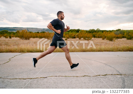 Athletic Man Jogging in the Sun, Preparing His Body for Life's Extreme Challenges Athletic Man Jogging in the Sun, Preparing His Body for Life's Extreme Challenges 132277385