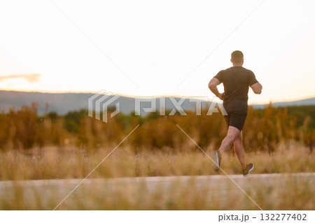 Athletic Man Jogging in the Sun, Preparing His Body for Life's Extreme Challenges 132277402