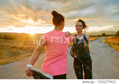 Two Women Athletes Stretching at Sunset in Beautiful Natural Surroundings 132277421