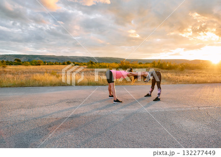 Womens Athletes Stretching at Sunset in Beautiful Natural Surroundings Womens Athletes Stretching at Sunset in Beautiful Natural Surroundings 132277449