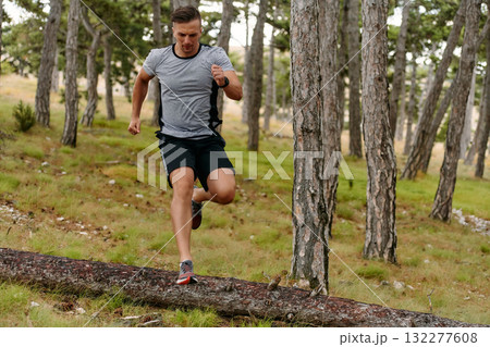 Determined Man Conquering Forest Obstacles with Grit and Speed 132277608