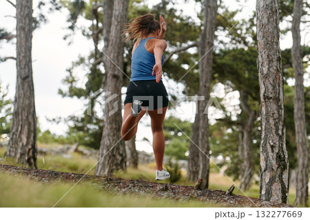 Fearless Woman Conquering Wooden Obstacles in the Dangerous Forest Terrain. 132277669