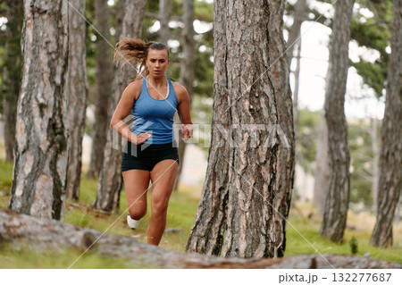 Fearless Woman Conquering Wooden Obstacles in the Dangerous Forest Terrain. Fearless Woman Conquering Wooden Obstacles in the Dangerous Forest Terrain. 132277687
