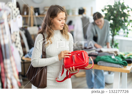 Young woman choosing handbag in clothing store Young woman choosing handbag in clothing store 132277726