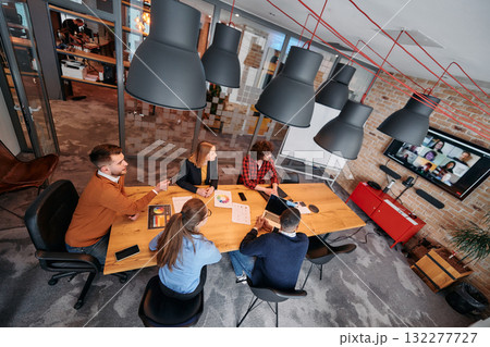 Top view of a modern startup office, a diverse team of business professionals engage in discussions on various projects and develop new business strategies, epitomizing creativity and innovation in 132277727