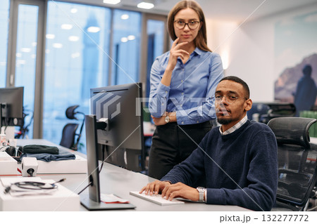 Digital Collaboration: Blonde Businesswoman and African American Partner Reviewing Documents Online 132277772