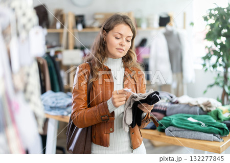 Young woman choosing gloves in clothing store 132277845