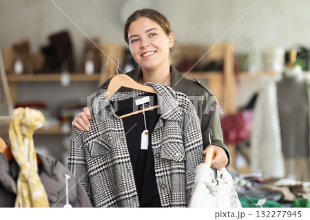 Female shopper selects clothes for autumn winter season in clothing store Female shopper selects clothes for autumn winter season in clothing store 132277945