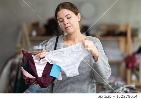 Young woman chooses underwear in clothing store Young woman chooses underwear in clothing store 132278014