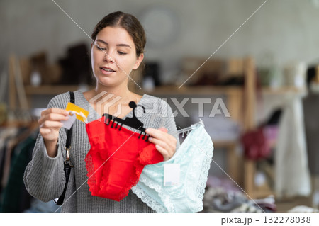 Uncertain young girl choosing panties in clothing store 132278038