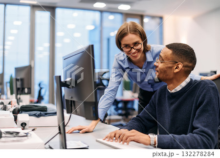 Digital Collaboration: Blonde Businesswoman and African American Partner Reviewing Documents Online 132278284