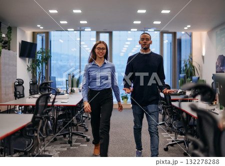 Dynamic Business Collaboration: Blonde Businesswoman and African American Colleague in Modern Office Setting. 132278288