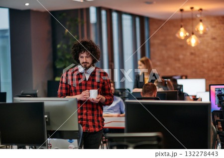 Focused Professional: Interesting Man with Coffee Cup in Office Surrounded by Computers. 132278443