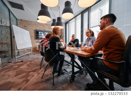 A diverse team of business professionals engage in discussions on various projects and develop new business strategies, epitomizing creativity and innovation in the entrepreneurial landscape 132278533