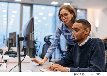 Digital Collaboration: Blonde Businesswoman and African American Partner Reviewing Documents Online 132278568